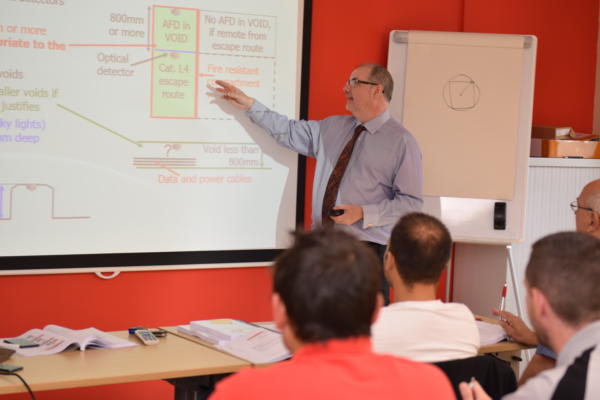 Image: Trainer and Technical Manager Will Lloyd stands teaching the class 